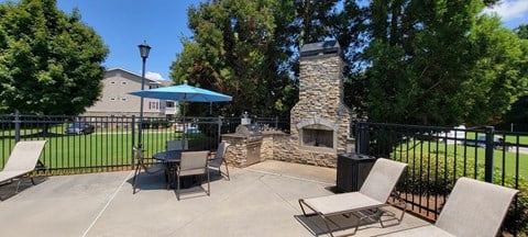 Poolside grilling station with stacked stone fireplace at The Columns at Oakwood, Oakwood 30566